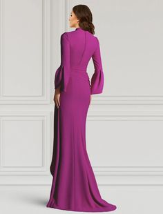 a woman in a long purple dress standing against a white wall with her back to the camera