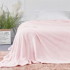 a pink blanket is on the floor next to a plant and a sign that says, you can't sleep