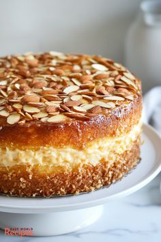 a cake with almonds on top sitting on a plate