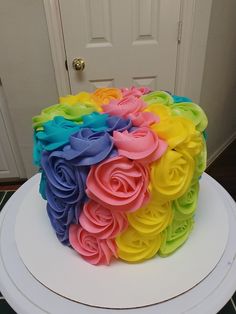 a multicolored cake sitting on top of a white table next to a door