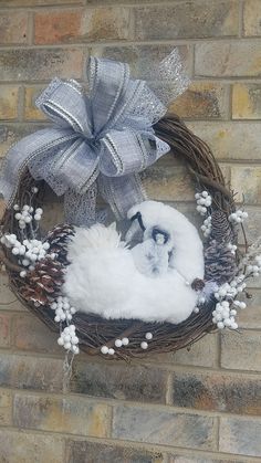 a wreath with a bird and pine cones hanging on the side of a brick wall