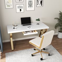 a white desk with a laptop computer on top of it next to a potted plant