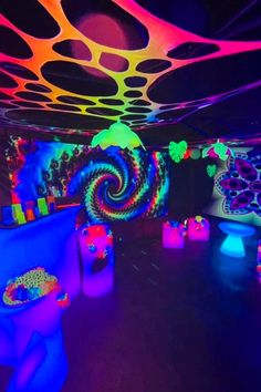 an indoor party with colorful lights and decorations on the ceiling, including balloons in the shape of spirals