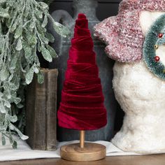 a snowman is next to a christmas tree and other holiday decorations on a shelf