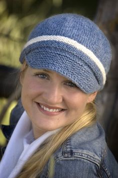 a young woman wearing a blue hat and smiling at the camera with long blonde hair