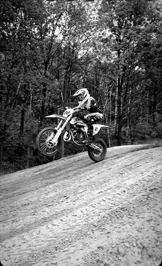 a person on a dirt bike jumping over a hill