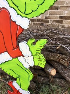 the grinch is sitting on top of a fire hydrant in front of a brick wall