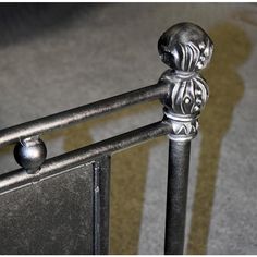 an iron bed frame with decorative knobs and finials