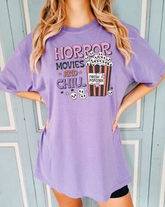 Looking for the perfect Halloween t-shirt for the Horror Movie lover in your life? This cute Comfort Colors Horror Movies and Chill shirt would make the perfect gift for any Horror Movie fan in your life.  Comes in multiple colors! Check out more designs here: www.etsy.com/shop/jadeandroseshop ✨️SIZE AND FIT: Your shirt will be printed on a high-quality, soft and comfortable unisex t-shirt. Sizes run true to size, which takes the guesswork out of ordering. If you like your t-shirts loose or over Purple Cartoon Print Fun T-shirt, Trendy Cotton Halloween Tops, Trendy Cotton Tops For Halloween, Halloween Letter Print Cotton T-shirt, Halloween Cotton T-shirt With Letter Print, Halloween Novelty Cotton T-shirt, Trendy Halloween T-shirt With Cartoon Print, Fun Skull Print Crew Neck T-shirt, Halloween Fun Skull Print T-shirt