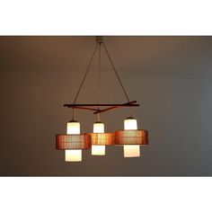 three lights hanging from a wooden beam in a room