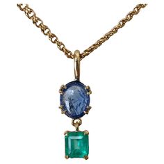 Gorgeous Vintage Pendant Drop Necklace. Natural untreated 4.40 carat Burmese vibrant cornflower blue color sapphire cabochon with emerald cut Colombian emerald approx 1.80 carat, set in 18k yellow gold. The pendant is accompany by a 18.5" chain 14K yellow gold. The total weight of the necklace is 12.5 grams. Pendent necklace is in very good condition.