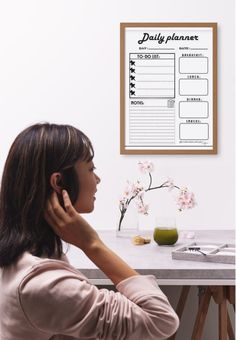 a woman sitting at a table talking on her cell phone while looking at the menu