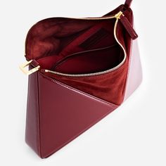 Our architectural, origami inspired shoulder bag, now has a new dimension. It can be converted into a wrist bag just with a quick move. The shoulder strap can easily be removed, so you can slung it from your wrist or use as a clutch. It has plenty of room inside for your essentials including a large phone, small wallet, and 300 ml water bottle. Made from smooth leather and has a suede top with two-way zip fastening. Interior features two slip pockets. Crafted from Italian patent leather. Canvas Modern Office Clutch With Detachable Strap, Luxury Bag With Removable Geometric Pouch, Luxury Geometric Bag With Removable Pouch, Luxury Geometric Shoulder Bag With Removable Pouch, Luxury Geometric Shoulder Bag For Everyday Use, Modern Geometric Shoulder Bag With Removable Pouch, Elegant Geometric Bag With Removable Pouch, Modern Shoulder Clutch For Business, Geometric Leather Shoulder Bag For Evening