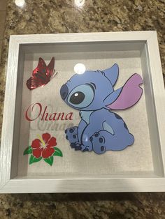 the stitcher art is in a shadow box with an elephant and butterfly on it