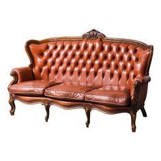 a brown leather couch sitting on top of a wooden frame