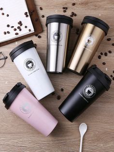 four different types of coffee cups and spoons on a wooden table with coffee beans