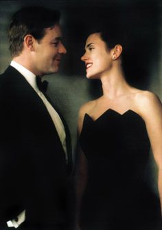 a man in a tuxedo standing next to a woman in a black dress