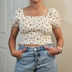 American Eagle Ruched Cropped Puff Sleave Top Cream Medium Floral This American Eagle Outfitters Blouse Features A Beautiful Floral Pattern And Puff Sleeves For A Touch Of Femininity. The Top Has A Cropped Length And A Ruched Design For Added Style. It Is Made Of A Soft And Stretchy Material That Is 60% Polyester And 40% Elastane. The Blouse Has A Pullover Closure And Short Sleeves, Making It Perfect For Travel Or Casual Occasions. It Comes In Size Medium, And The Color Is Ivory. This Top Is Per Wrap Tank Top, American Eagle Crop Top, Crochet Boho Top, Cowl Neck Long Sleeve, Small Crop Tops, Floral Color, Floral Crop Tops, One Shoulder Tops, Crop Blouse