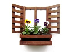 some flowers are in a wooden window box