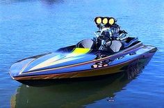 a man riding on the back of a blue and yellow jet ski boat in water