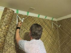 a man that is standing in front of a wall with some tape on it's side