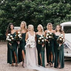 a group of women standing next to each other in front of an old white car