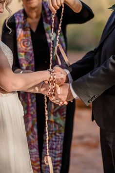 the bride and groom are holding hands together