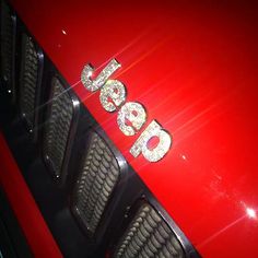 the front end of a red car that has been decorated with silver letters and numbers