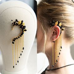 a woman wearing black and gold earrings on her head next to a mannequin