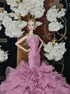 a barbie doll wearing a pink dress with flowers in the background