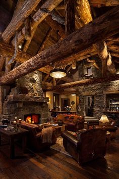 a living room filled with furniture and a fire place in the middle of a wooden floor