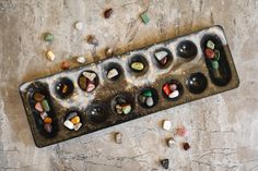 a metal tray filled with lots of different colored rocks and stones on top of a table