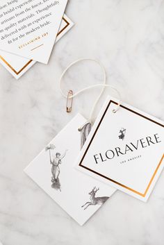 two tags with the words floravre hanging from them on a marble counter top