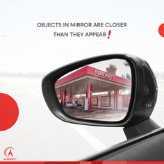 a side view mirror with the reflection of a gas station on it's side