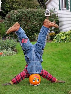 a person upside down on their back in the grass with an orange ball behind them