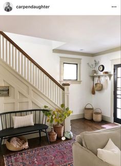 a living room filled with furniture next to a stair case