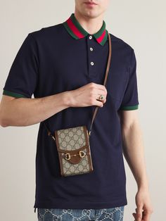 Gucci's pouch bears a number of recognisable brand signatures, from the equestrian-inspired horsebit hardware to the house's archival 'GG' emblem printed throughout. Designed in a slim profile to fit just your essentials, phone and cardholder, for instance, it's equipped with an adjustable shoulder strap and reinforced with contrasting brown leather trims. Gucci Pouch, Shoulder Bag Outfit, Sling Bag Men, Mini Sling Bag, Gucci Collection, Mini Outfit, Gucci Mini, Gucci Horsebit, Luxury Men