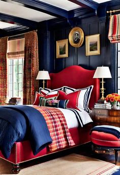 a bedroom decorated in blue and red with striped bedding, plaid rugs, two lamps on either side of the bed