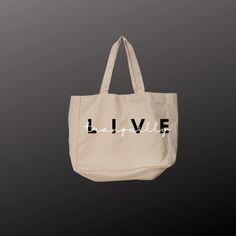 "LIVE Tranquilly and Sustainably! The cotton canvas tote bag is the ideal grab & go accessory - especially for last-minute shopping trips. Made of 100% cotton, this tote fits right in with any style.  Regular Tote: 6 oz., Cotton Canvas Basic flat tote 22 cotton canvas handles 14.5 x 15.5 Non-branded label/tag Large Tote: Self-fabric handles. Interior zippered pocket. 22\"W x 16\"H x 6\"D   24\" Handles Imprint: 8\"W x 6\"H CARE INSTRUCTIONS: Before cleaning the bag, remove all the items from the Large Capacity Cotton Canvas Shopping Bag, Cotton Canvas Bag With Canvas Lining For Shopping, Cotton Canvas Bag For Shopping, Large Everyday Canvas Gift Bag, Everyday Large Capacity Cotton Bag, Large Capacity Cotton Bag For Everyday Use, Everyday Canvas Bag With Letter Print, Eco-friendly Everyday Cotton Bags, Large Cotton Canvas Bag For Everyday