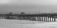 a pier on the ocean with people walking along it