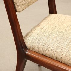 a close up of a wooden chair with fabric on it