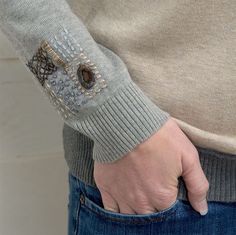 a close up of a person's hand wearing a sweater