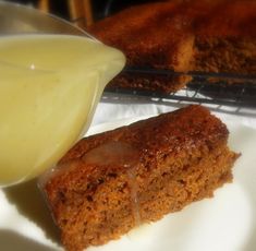 a piece of cake sitting on top of a white plate next to a glass container