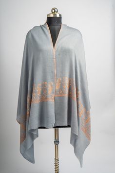 Step into understated luxury with our Misty Dawn Hand Embroidered Merino Wool Sozni Scarf. Woven from the finest merino wool, this scarf in a gentle grey hue is adorned with subtle orange sozni embroidery. The delicate floral motifs add a touch of elegance, making this scarf a versatile accessory for any occasion. Perfect for adding a sophisticated touch to your outfit, this scarf drapes effortlessly and provides a cozy yet stylish layer. The combination of soft colors and intricate embroidery m Luxury Elegant Scarves With Chikankari Embroidery, Sozni Embroidery, Misty Dawn, Embroidered Rug, Scarf Jacket, Embroidered Handbag, Silk Carpet, Understated Luxury, Pashmina Shawl