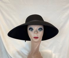 This black wool felt hat has an uneven side brim which measures 5 1/2 inches on one side and 4 inches on the other. The front measures 4 inches and the back 3 inches. This hat will fit 22 1/2 to a 22 3/4 inch head size. The black grosgrain ribbon is removable. NOTE: Please check the head size before purchase, I am happy to answer any questions you may have. There will be a 20% restocking fee for all returned hats. Adjustable Wide Brim Felt Hat For Evening, Adjustable Brimmed Felt Hat For Evening, Black Felt Hat For Fall, Wool Brimmed Hat For Party, Black Flat Brim Felt Hat For Kentucky Derby, Wool Brimmed Party Hat, Fitted Felt Cloche Hat With Wide Brim, Black Felt Hat With Flat Brim, Wool Cloche Hat With Curved Brim For Evening