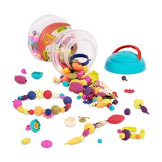 an open plastic container filled with lots of different colored beads and toys on a white surface