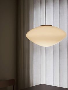 a light hanging over a table next to a window