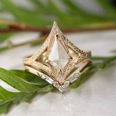 a diamond ring sitting on top of a leaf