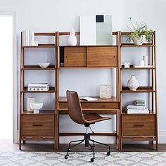 an office with a desk, chair and bookcase in the middle of the room