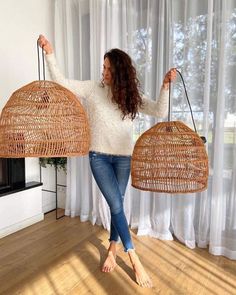 a woman holding two wicker baskets in her hands